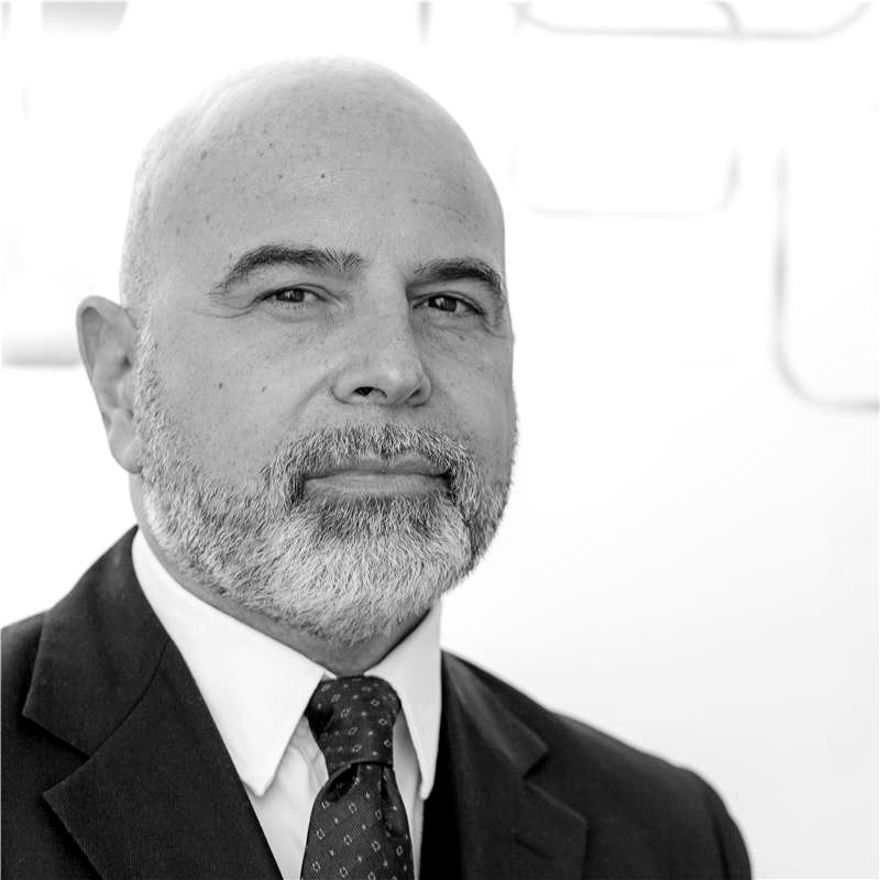 Black and white portrait of a middle-aged man with a beard and mustache, wearing a suit and tie, looking at the camera.