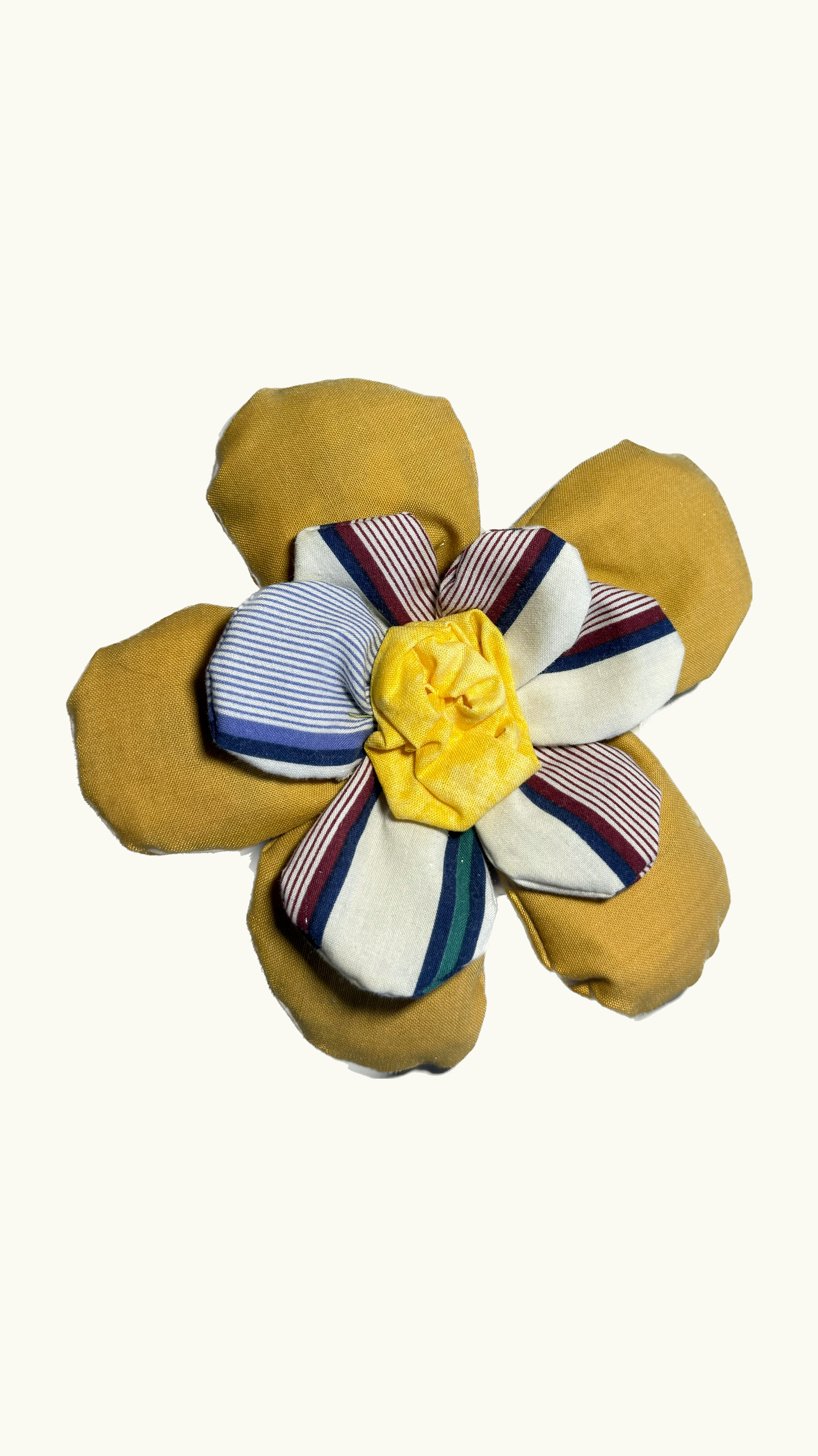 Fabric flower made from various colored and patterned fabric scraps, including yellow, striped blue and white, striped red and white, and plain yellow petals.