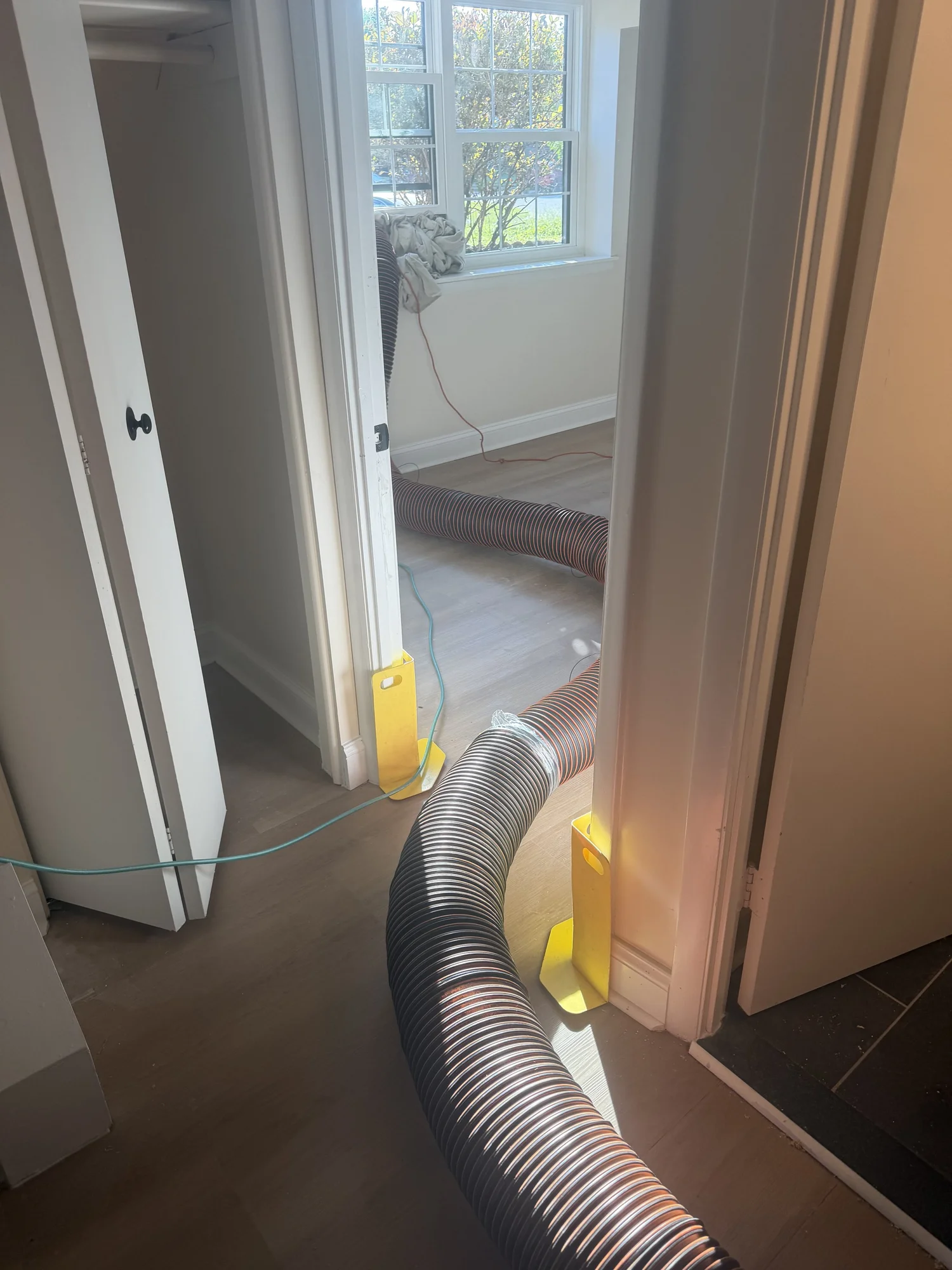 Air duct cleaning vacuum hose routed through a Catonsville Maryland home with corner protection