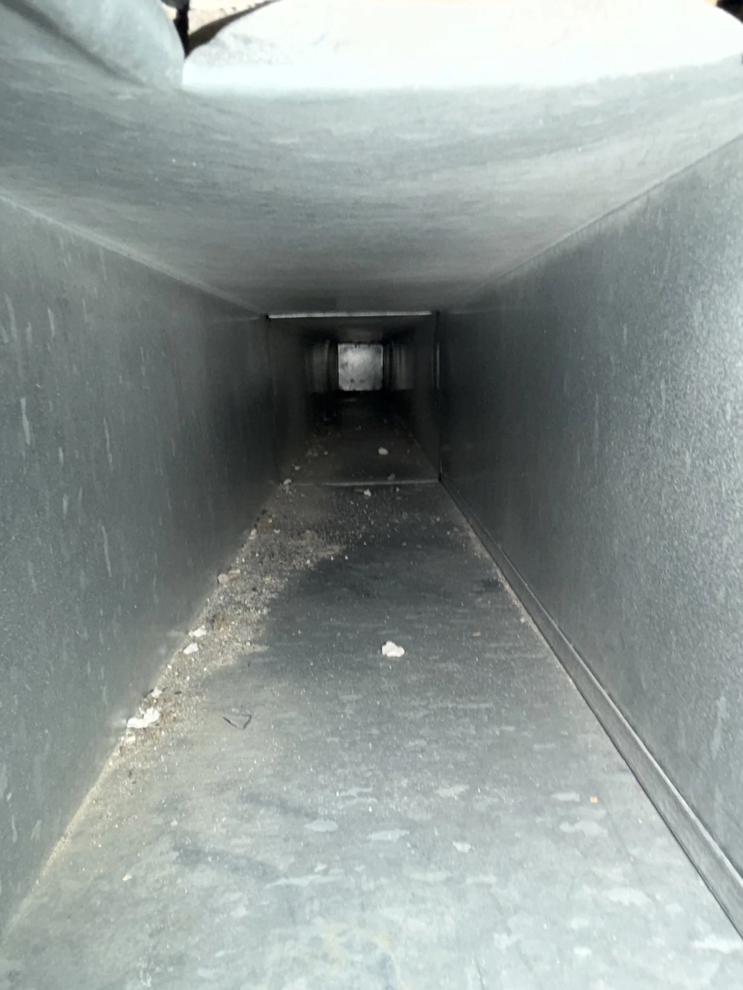 Debris inside residential air duct before cleaning in Catonsville Maryland