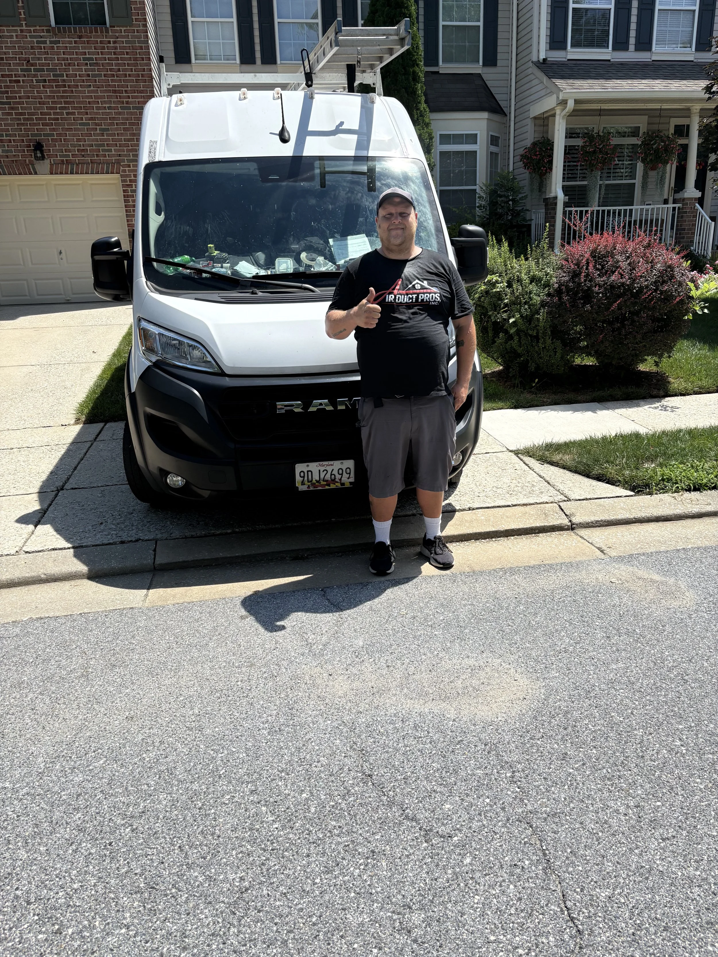 Air Duct Pros, Inc. technician standing in front of a company service van before a residential air duct cleaning appointment in Maryland.