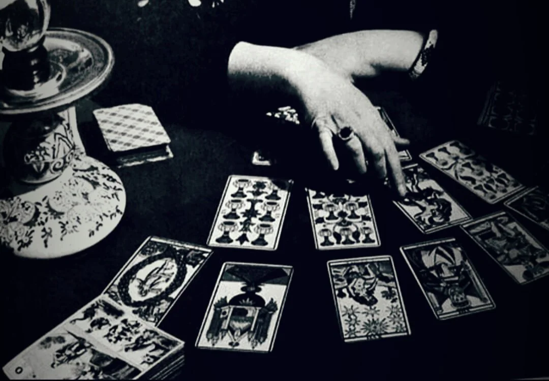 Une personne pratique le tarot de marseille, avec des cartes posées sur une table