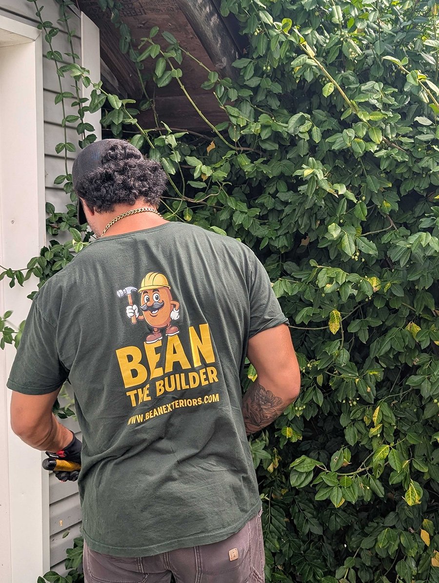 Bean crew trimming bushes around the exterior of a home