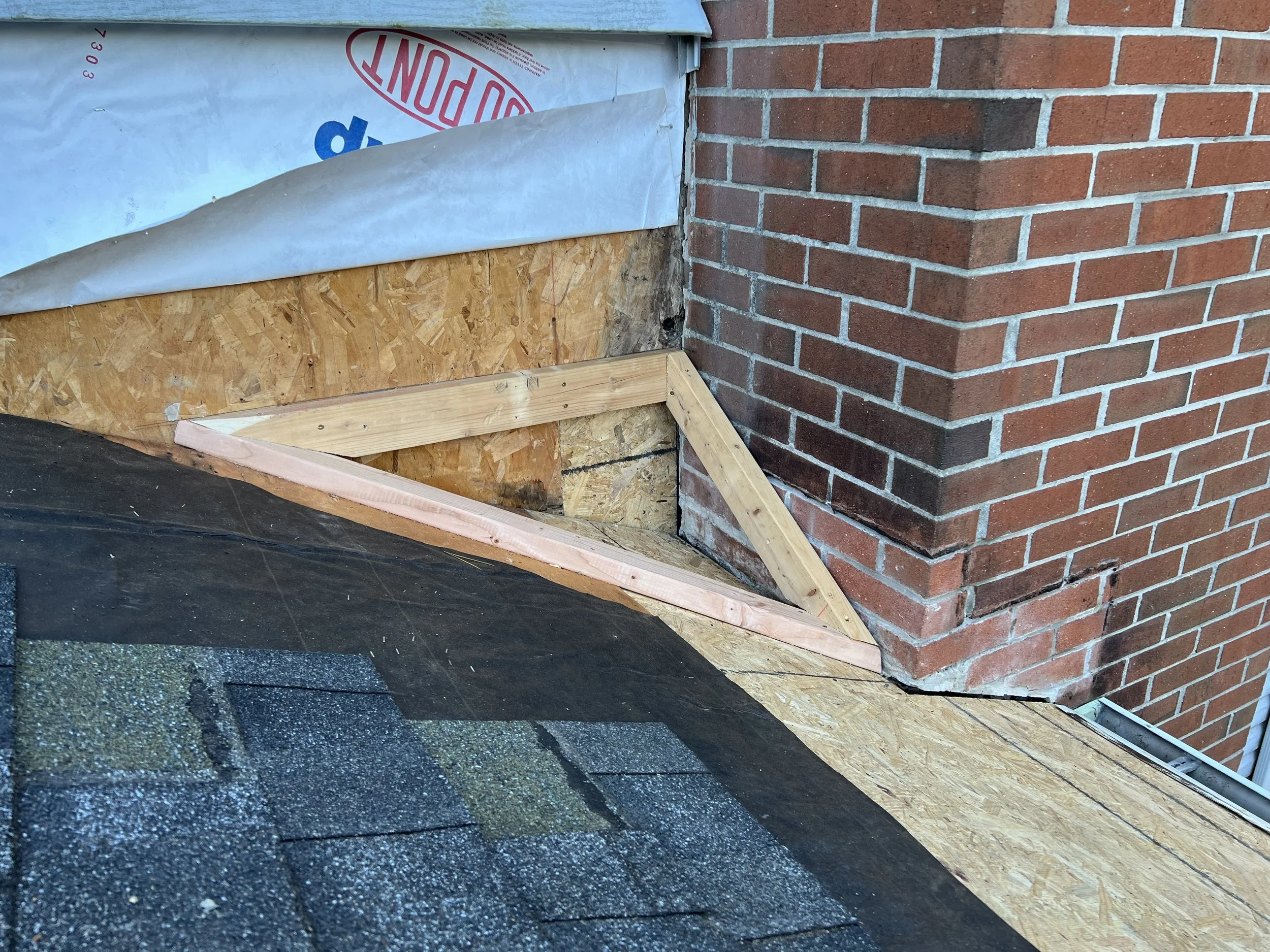 Building a small cricket diverted the water away from the inside corner created by the roof and chimney.