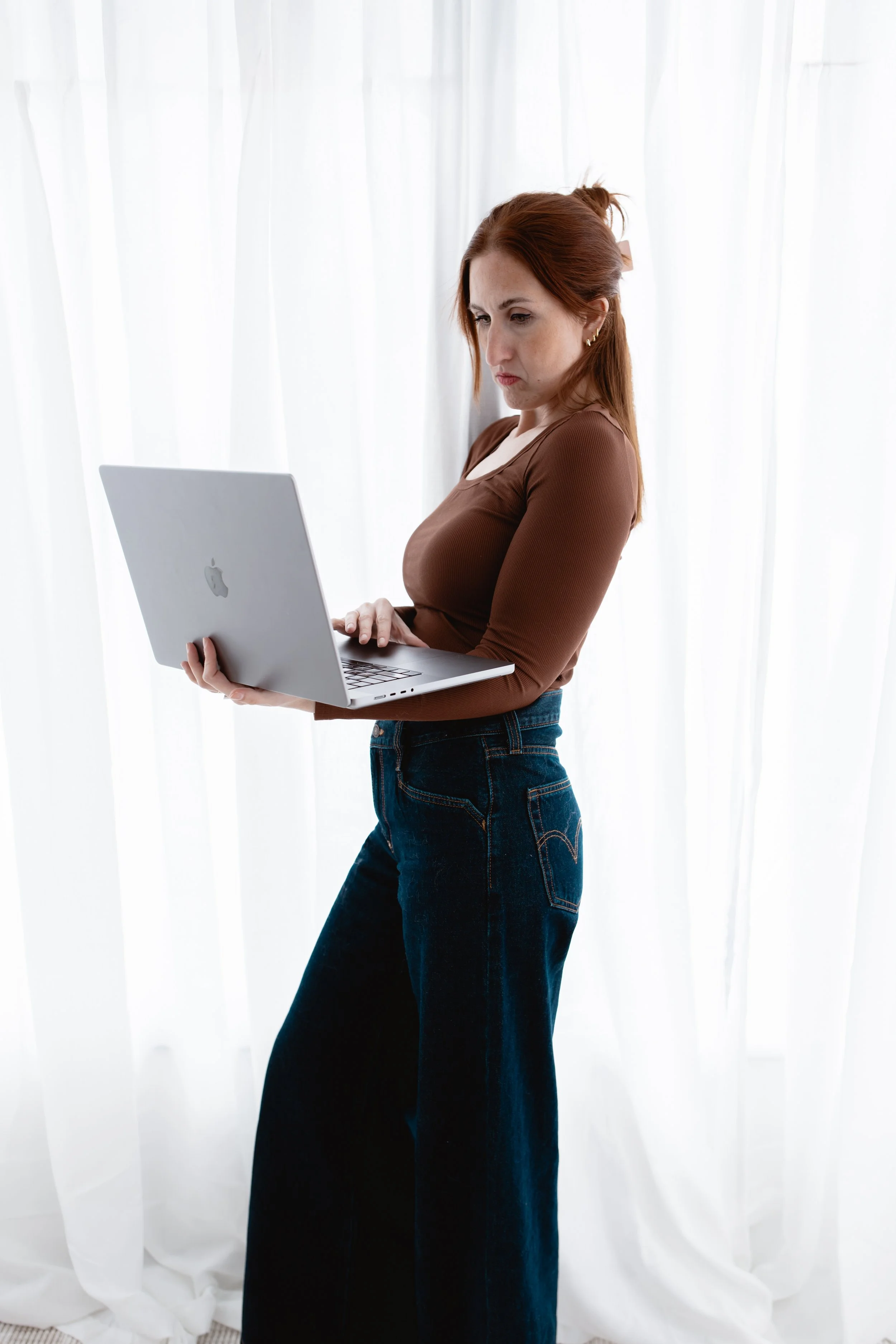 Therapist and consultant Samantha Skvaril standing with laptop, highlighting her expertise in working with late-diagnosed ADHD adults.