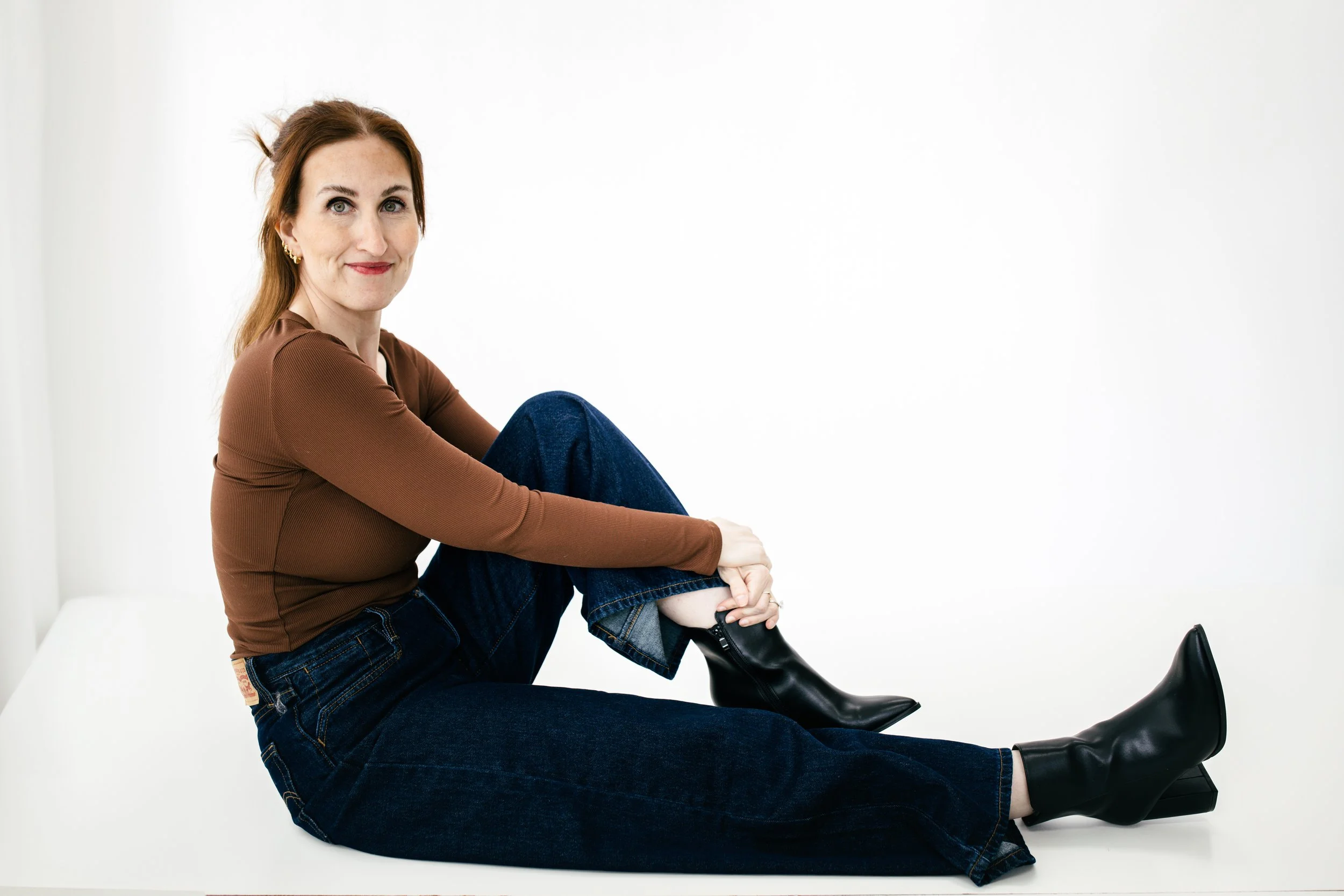 Samantha Skvaril, ADHD therapist, seated against a white background in a brown top and dark jeans