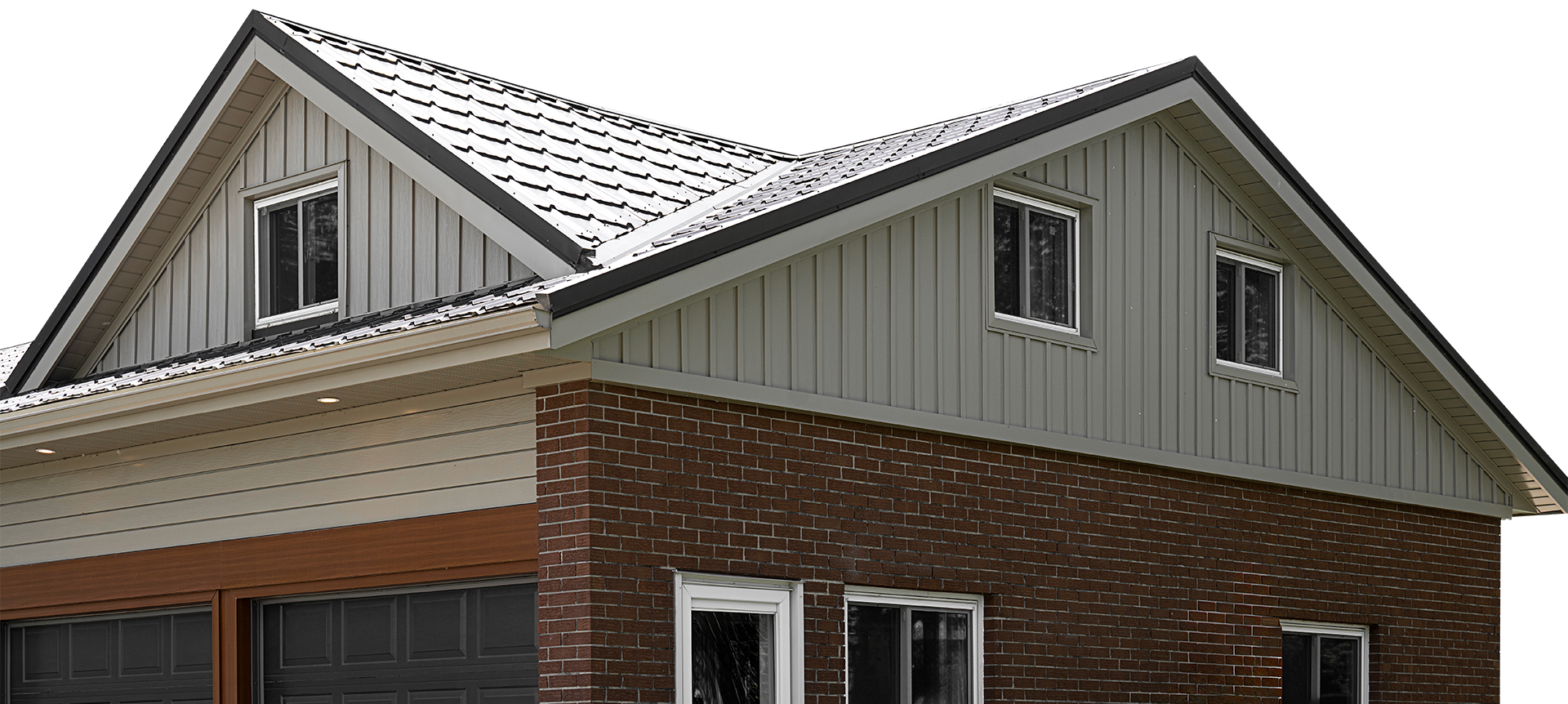 Close-up of a two-story house with a brick lower section, horizontal beige siding, and gray shingle roofing with dormer windows.