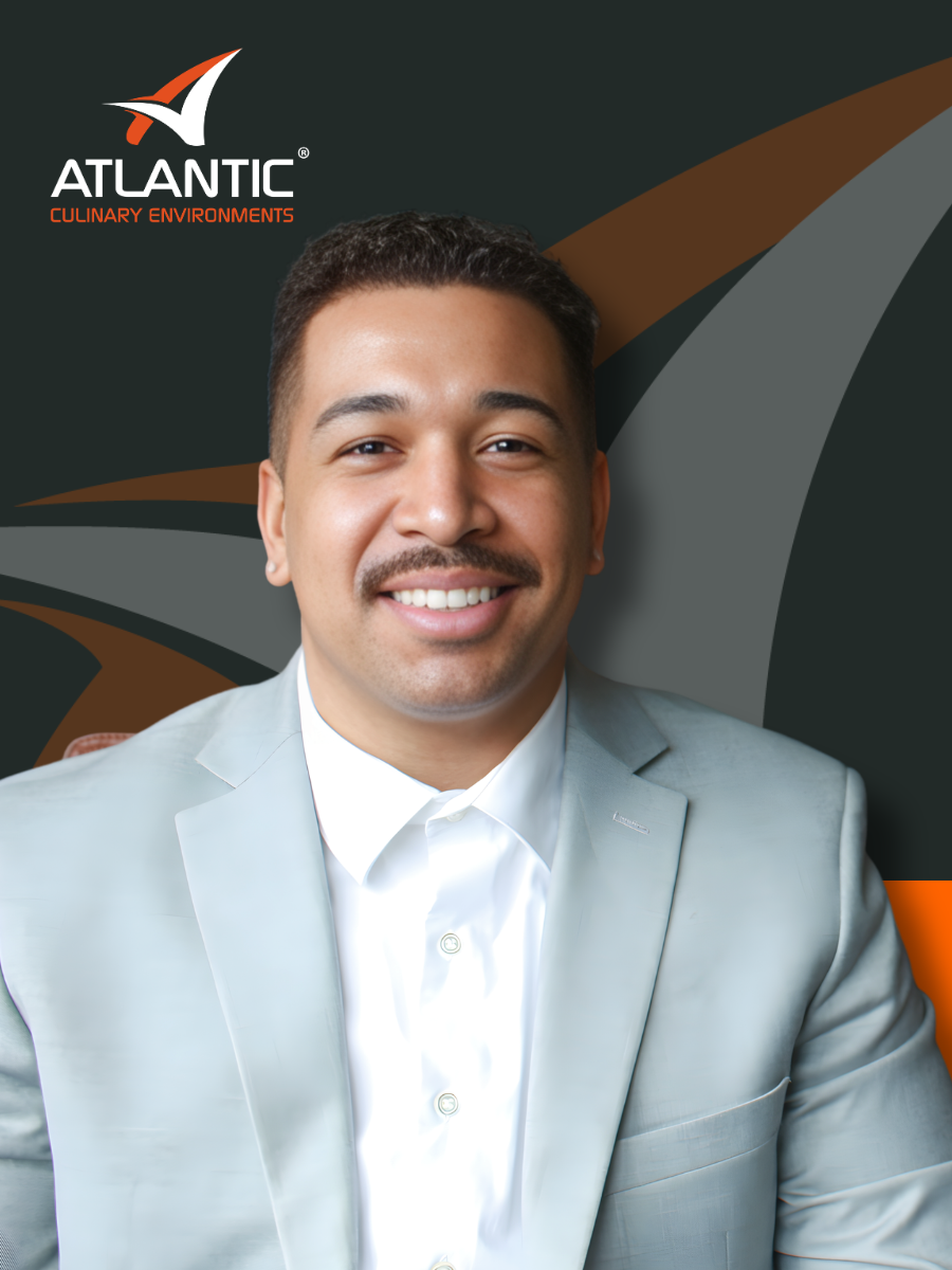 A smiling man in a light gray suit and white shirt, with the Atlantic Culinary Environments logo in the background.
