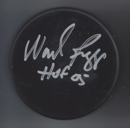 Signed black circular object with the text 'Walt Fraz' and 'Huck 09' written in white.