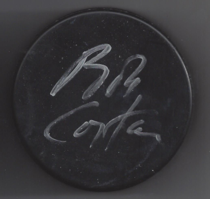 A black circular object with the handwritten words 'Riz Con' in white chalk.