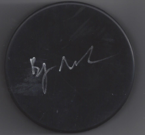 Black circular surface with white handwritten signature or writing.