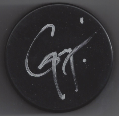 Close-up of a black circular object with white chalk writing that appears to say 'Go' or 'GQ'.