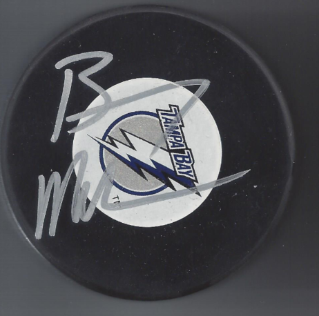 Hockey puck with the Vegas Golden Knights logo and a signature.