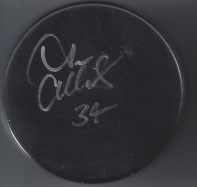 A black circular object with a signature and the number 34 written in white on it.