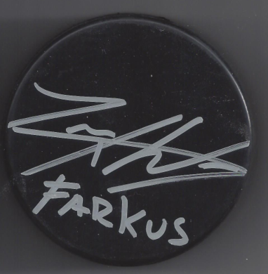 A black circular button with white handwritten text that reads 'FARKUS' and an illegible signature above it.
