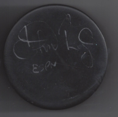 Black hockey puck with white scratched text that reads 'Hockey' and 'ESPN'.