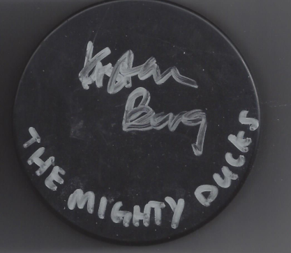 A round black puck with handwritten white text that says 'Kalamazoo Buds' and 'The Mighty Ducks'.