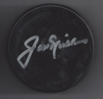 Close-up of a black hockey puck with a signature in white ink