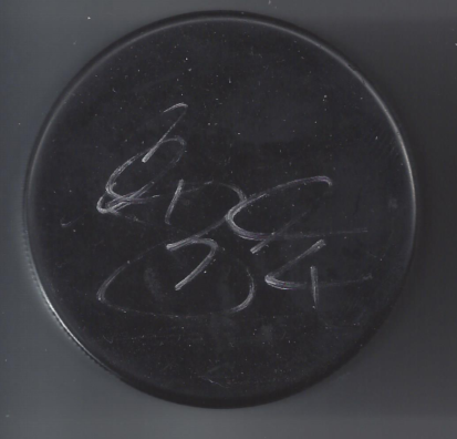 Close-up of a black circular surface with chalk markings that appear to be scribbles or writing.