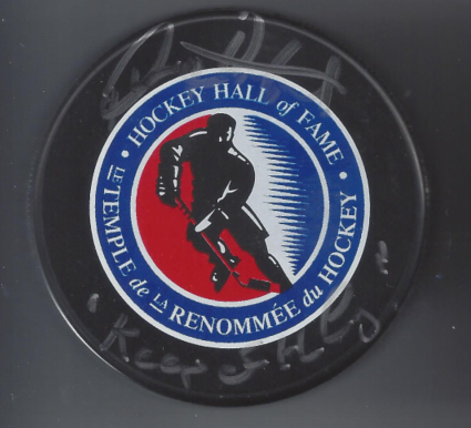 Hockey Hall of Fame logo with a silhouette of a hockey player holding a stick, surrounded by blue, white, and red colors.
