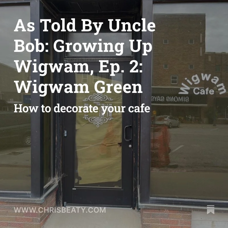 Glass door with white text about decorating a café, featuring a reflection of a parking lot and buildings outside.