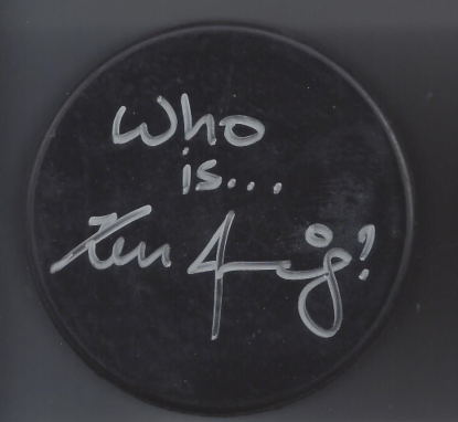 A circular black sign with white handwritten text reading, "Who is... Kan 4/9?"