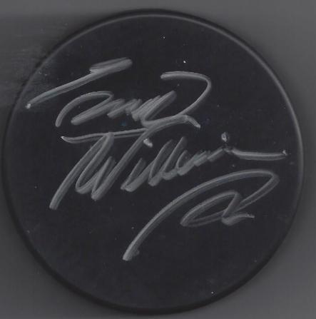 Autographed black circular object with silver ink signature.