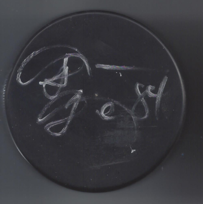 A circular black surface with white chalk writing that says 'J. Scott' or similar.