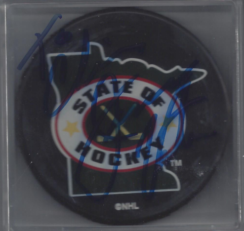 Hockey puck featuring the Minnesota State of Hockey logo inside a plastic case.