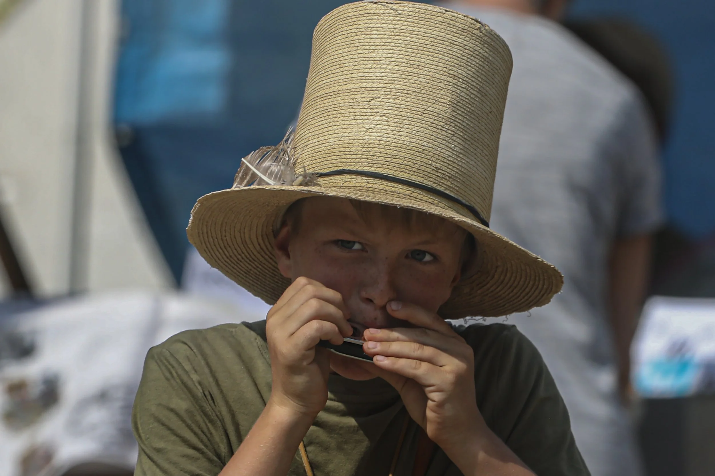 A young boy who was working for vendor Bob Walsh stood in the street one afternoon,  selling jewelry while playing his harmonica.