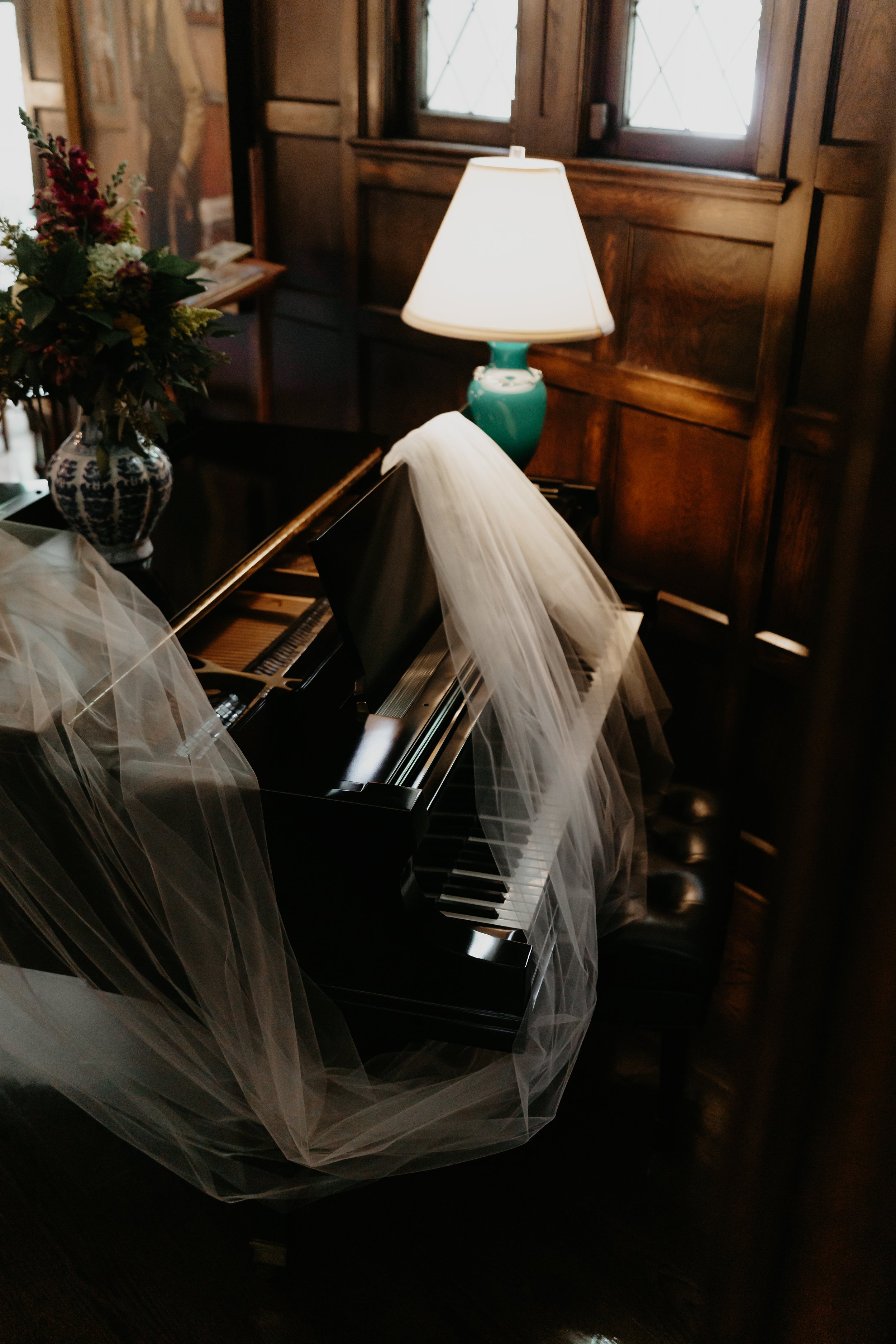 Bride’s long wedding veil draped across a piano inside the Ohio Governor’s Residence, photographed by Julia Brown Photo.