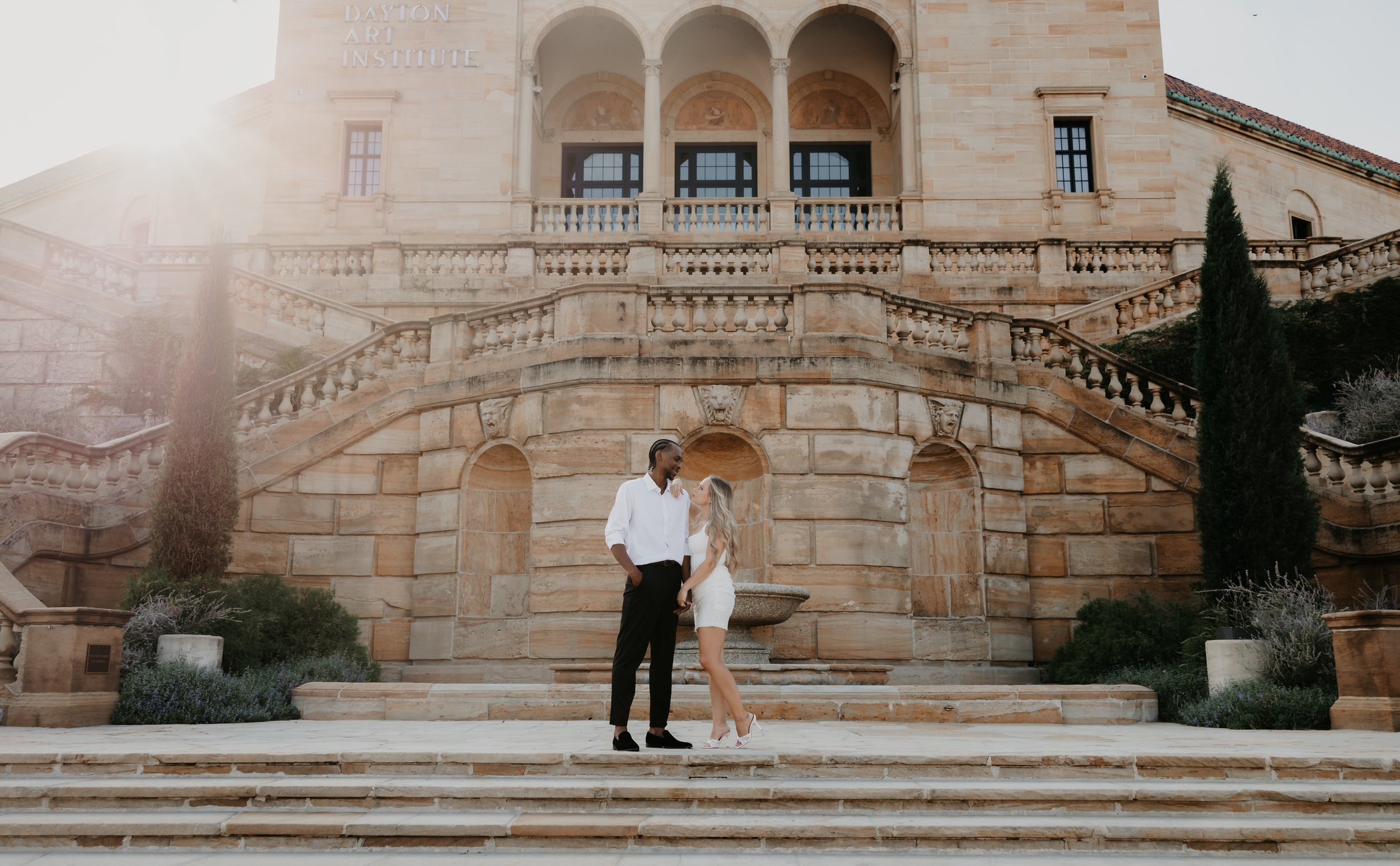 Engaged couple standing together on the grand staircase at the Dayton Art Institute in Dayton, Ohio.