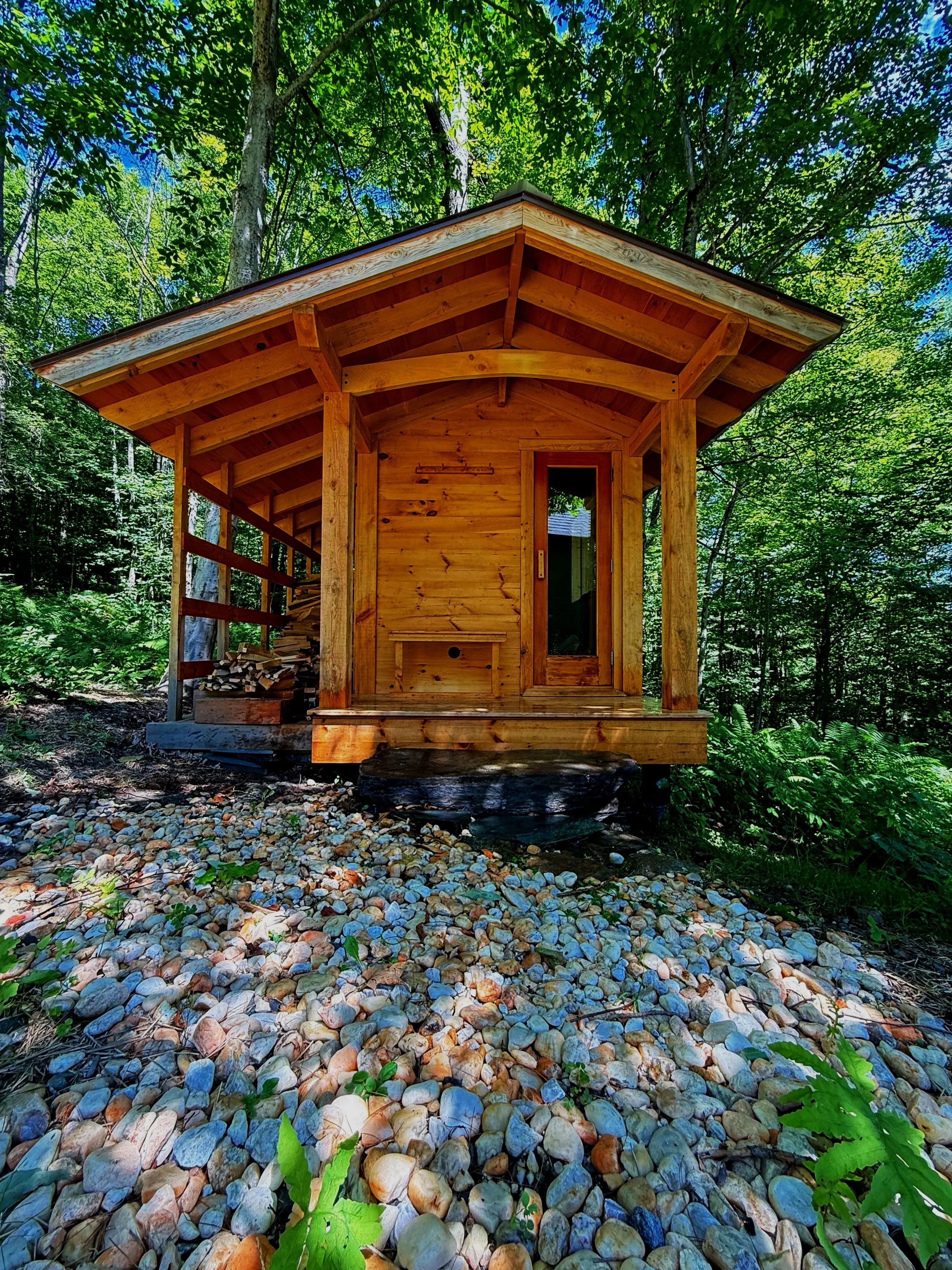 Custom outdoor sauna built by Hot Bird Saunas in a Vermont forest setting, featuring natural wood construction and thoughtful siting.