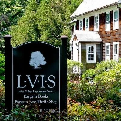 Sign for Ladies Village Improvement Society with trees and a house in the background.