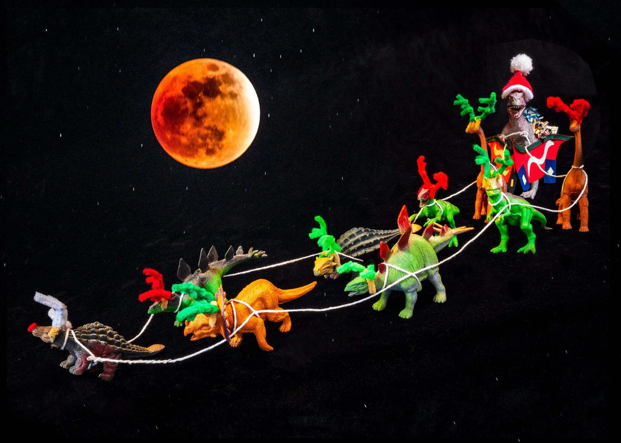 Santa sleigh with dinosaur reindeer against blood moon