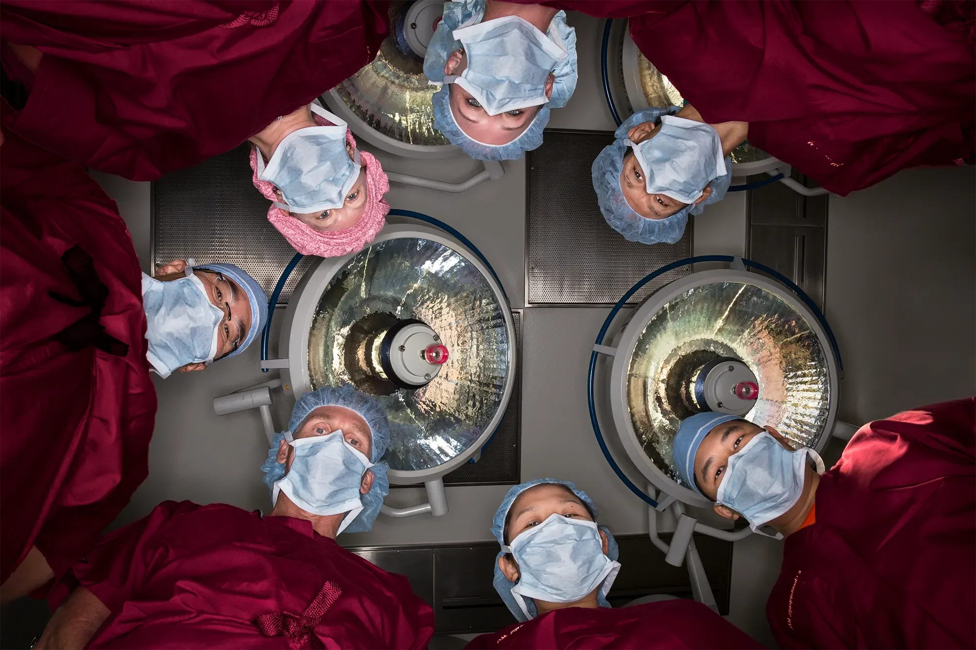 A group of anesthesiologists huddles around a table in the OR.