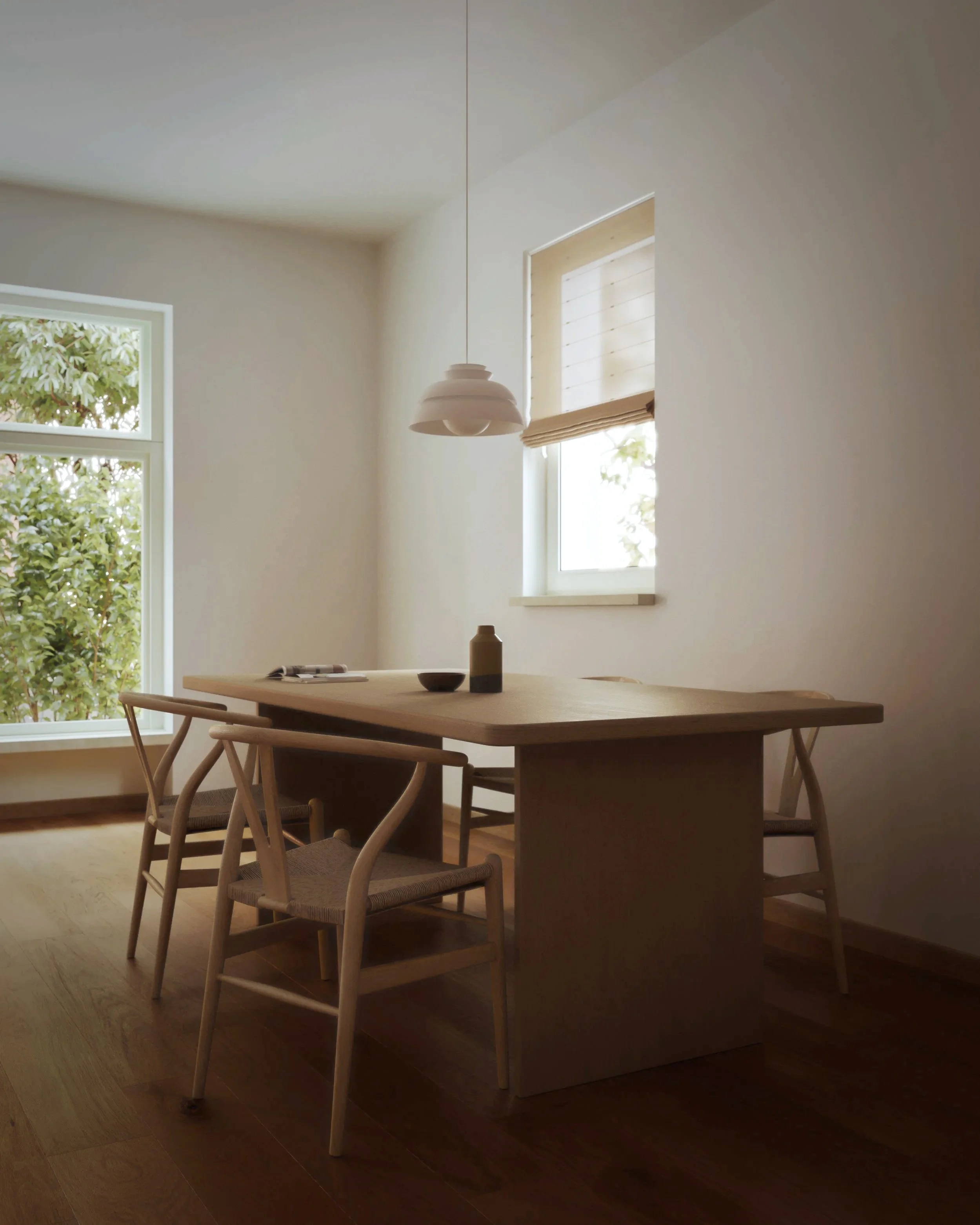 Minimalist dining room with wooden table, four chairs, large window with natural light, white walls, and a white pendant light.