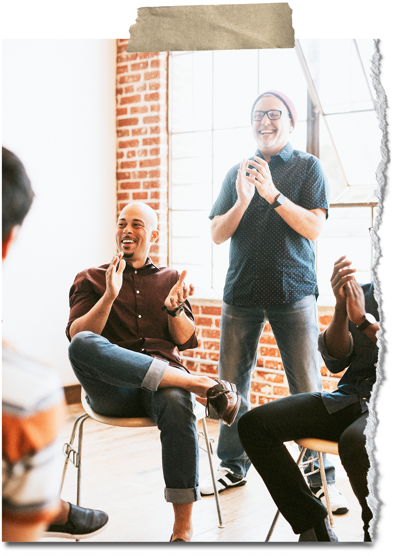 Group of people in a studio or workshop setting, engaging and laughing while participating in a discussion or activity.