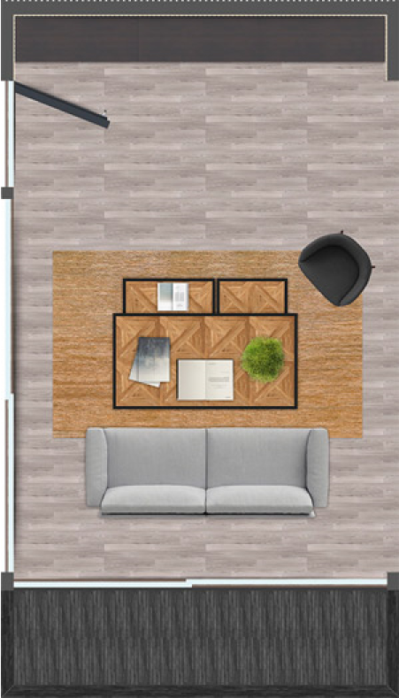 Vista aérea de una sala de estar con un sofá gris, una mesa de madera con libros y una planta, y una silla negra en una alfombra marrón sobre el piso de madera clara.