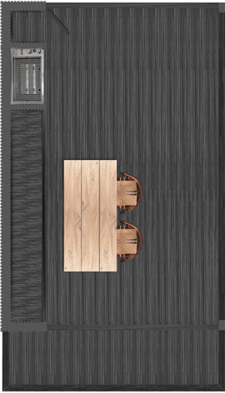 Vista aérea de una terraza con mesa de madera y dos sillas de mimbre. Al fondo, una pared de tablas de madera oscura y un área con piedra y plantas.