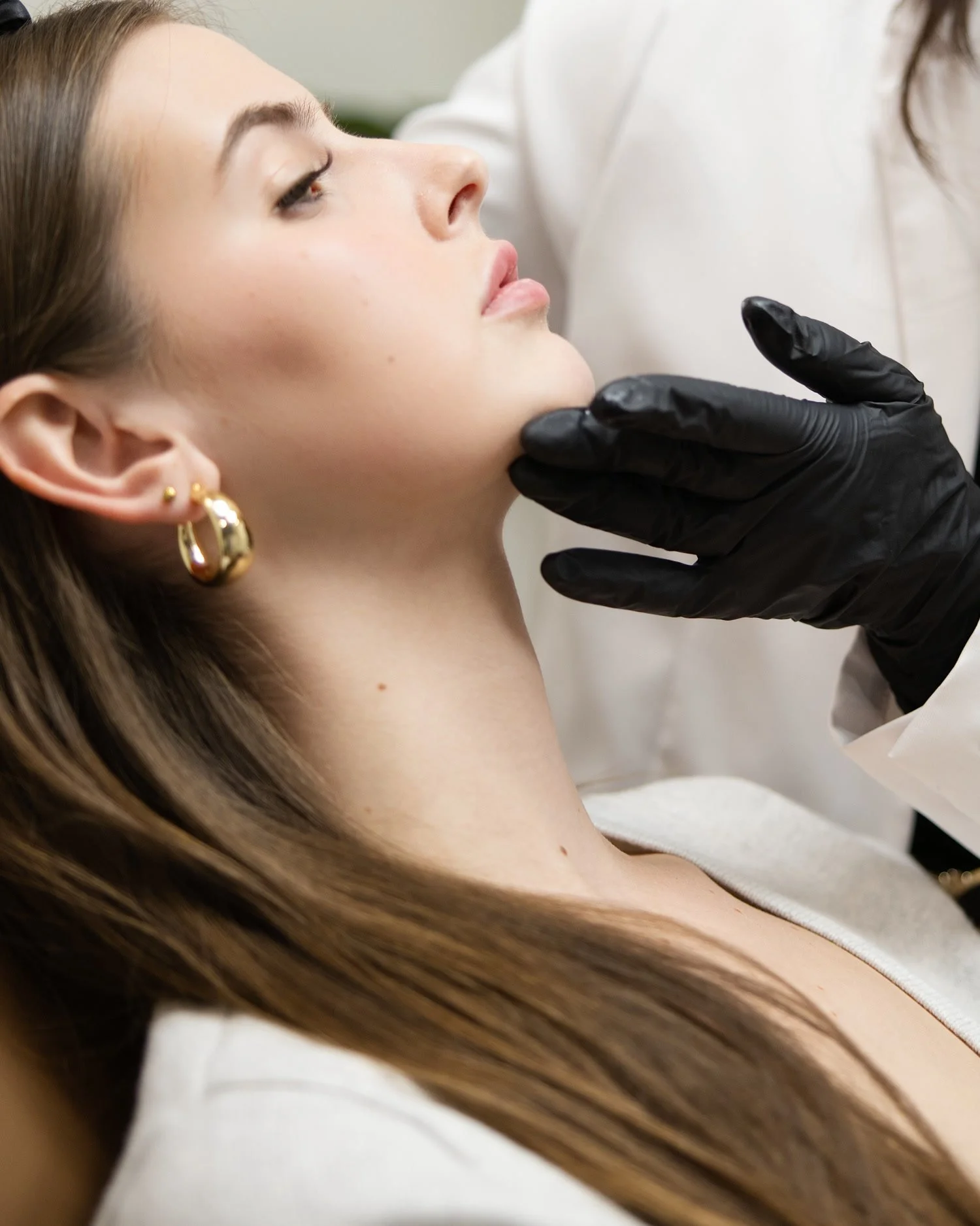 Client receiving a dermal filler assessment of the jawline at Luníc in Ottawa