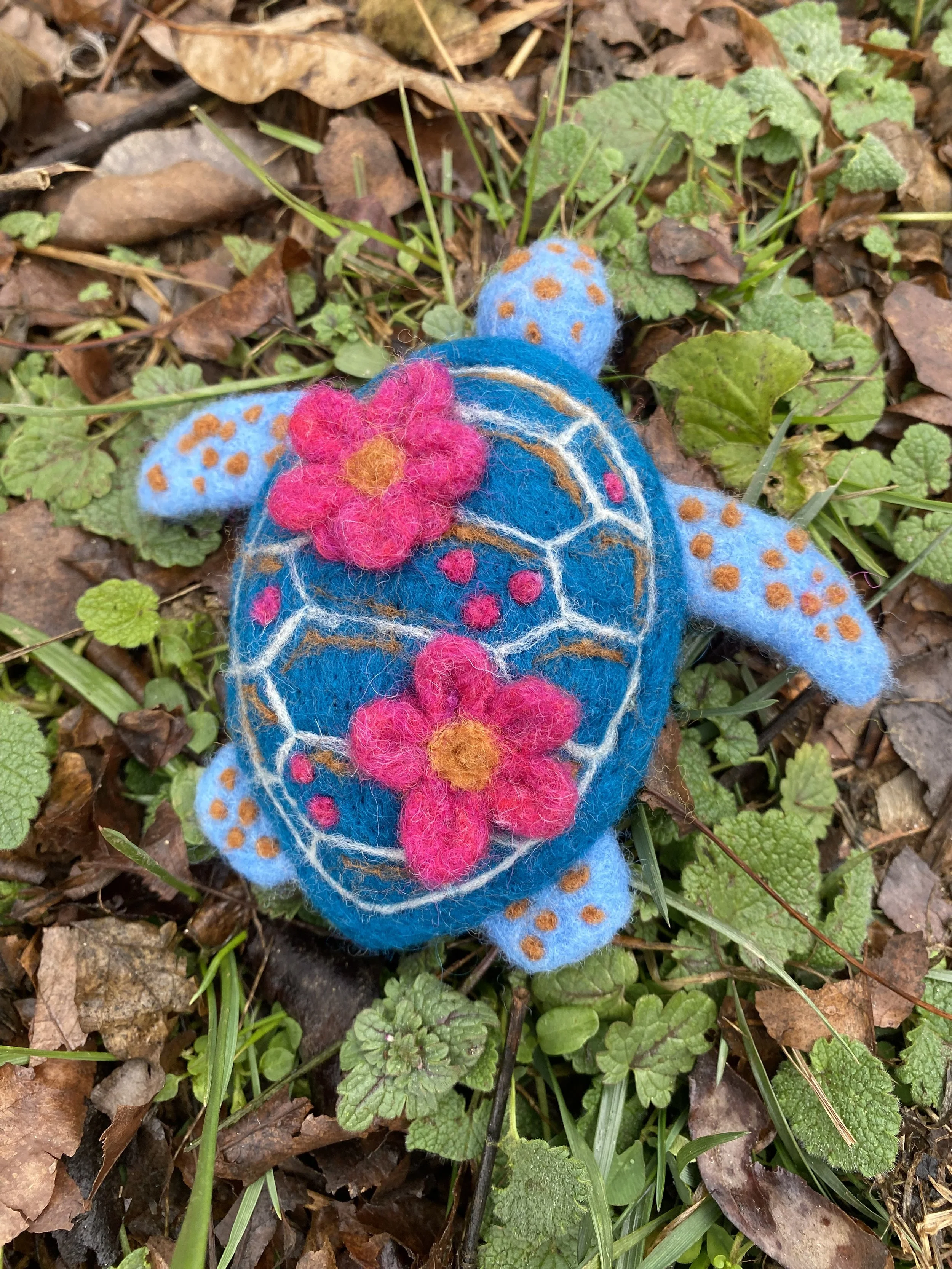 Blue turtle with pink flowers sculpture