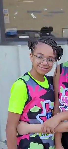 Elite basketball coach providing hands-on demonstration and positive reinforcement for middle school athletes.