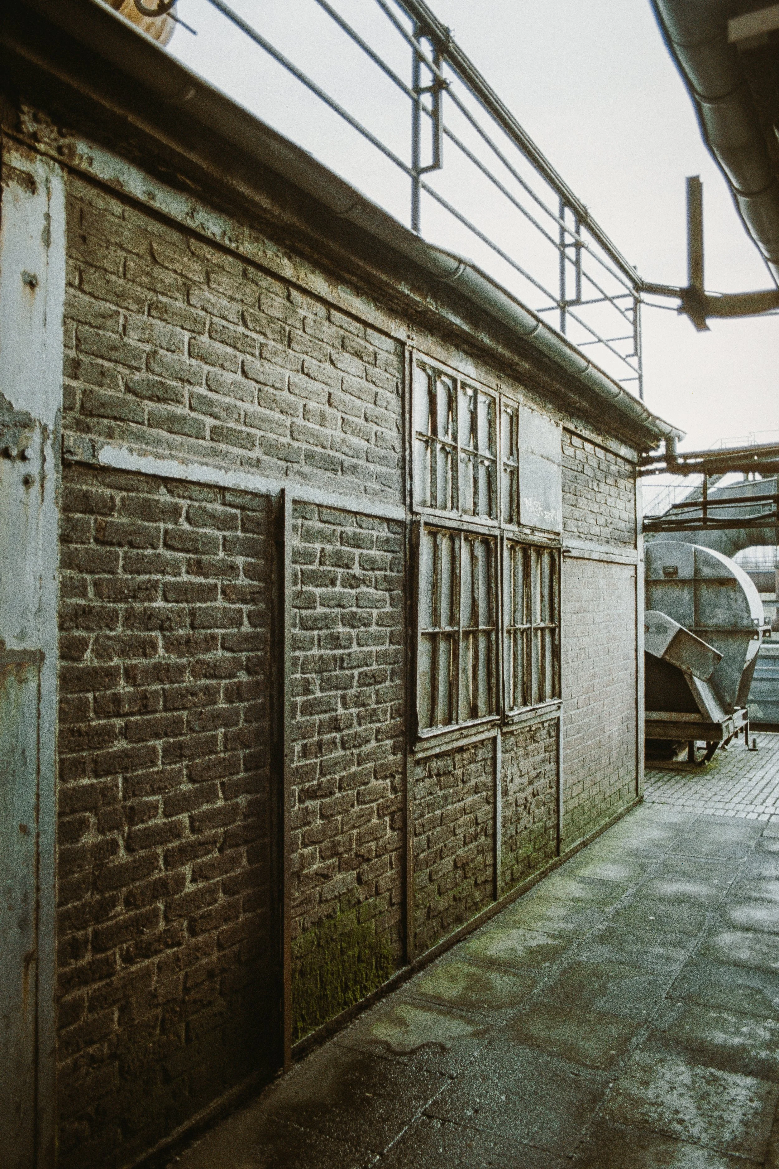 Brückenmauer mit altem Fenster und Rohrleitungen, Industriestil