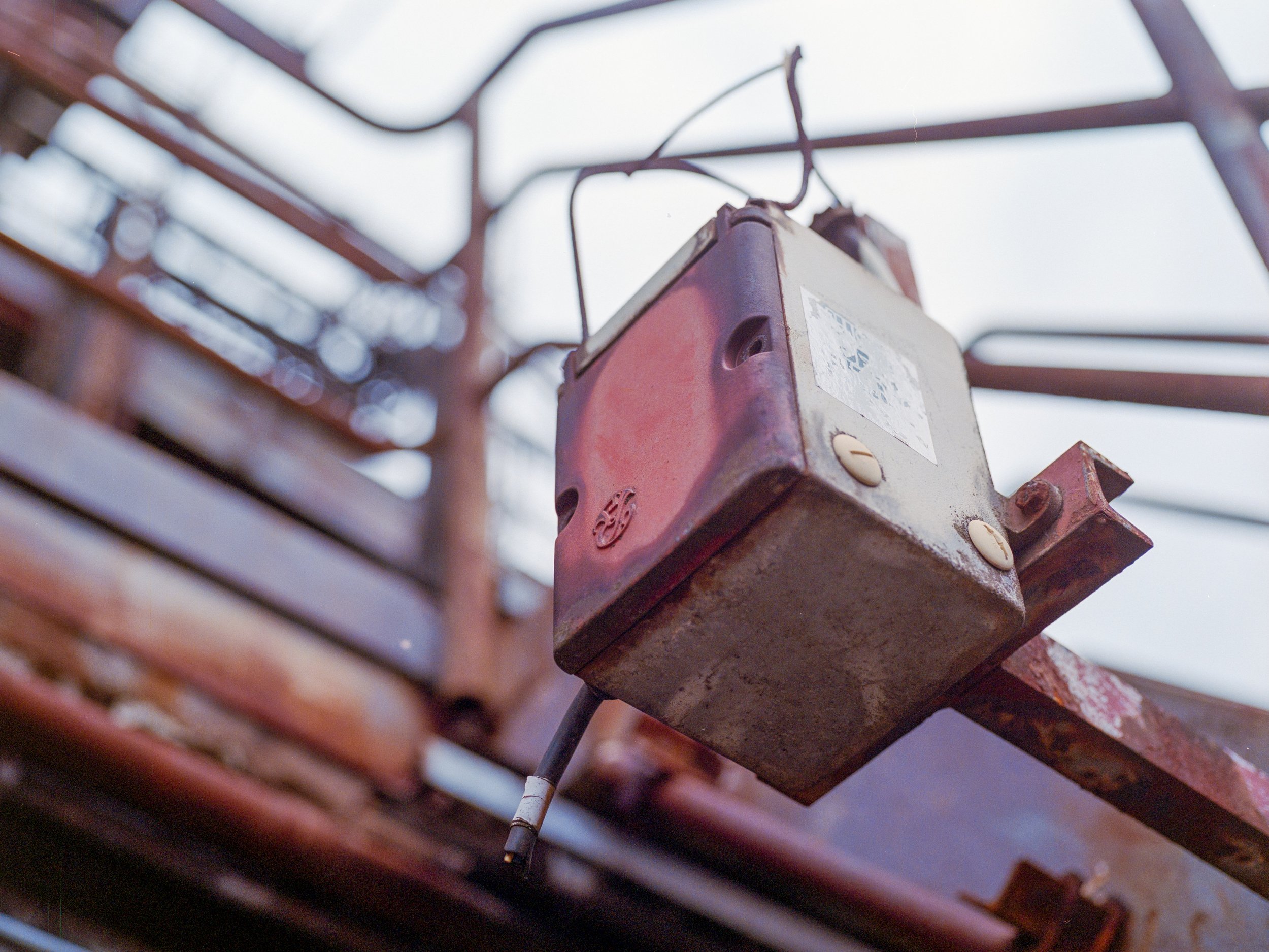 Alte, rostige elektrische Steuerbox an einem Baugerüst im Freien.