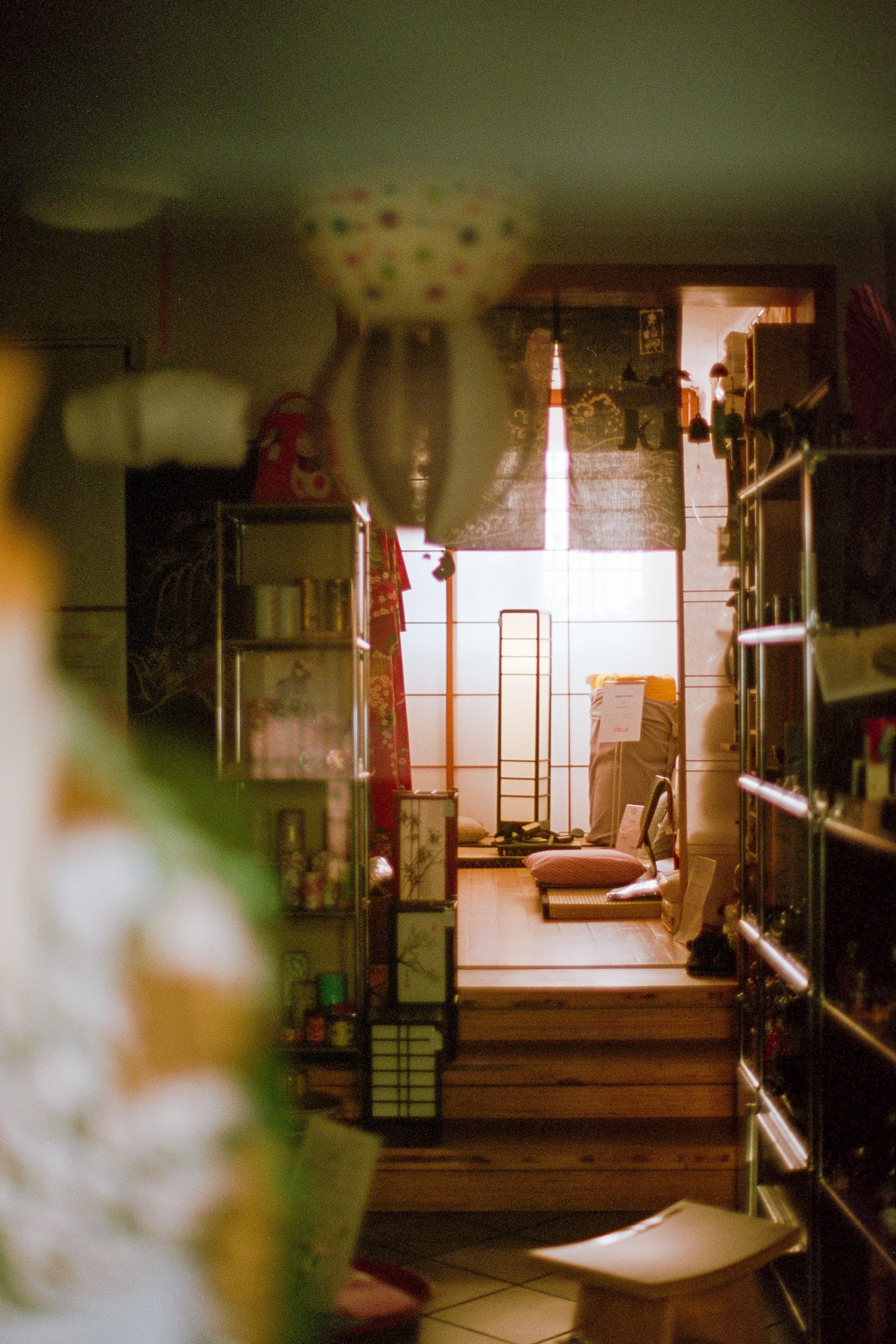 Innenansicht eines Ladens mit Blick auf einen japanisch inspirierten Raum im Hintergrund, der durch eine Schiebefensterwand getrennt ist.