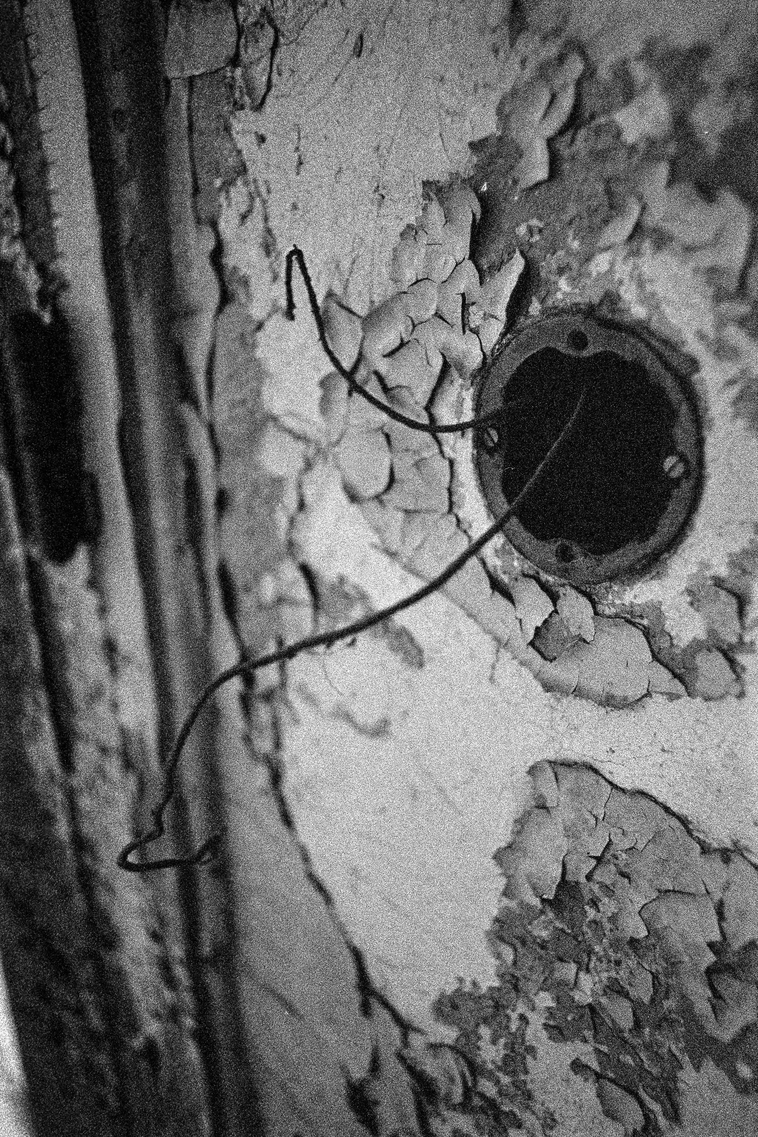 Verfugen an einer Wand, die an der Oberfläche abgeblättert ist, mit zwei dünnen Drähten.