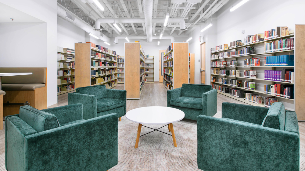 Four green velvet armchairs around a round table in the CBI Library