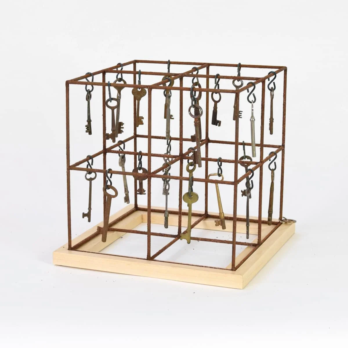 A 3D metal key rack with multiple antique keys hanging from hooks on a white background.