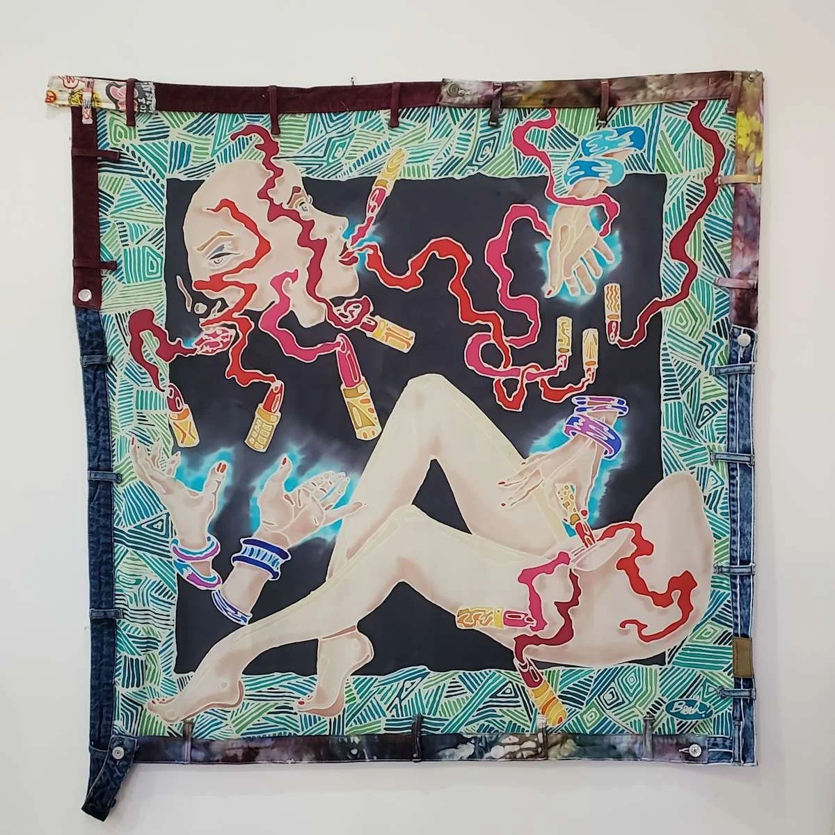 A colorful painting of a woman with blond hair, surrounded by abstract patterns, holding a lit cigarette, with red, pink, blue, and yellow smoke or design elements emerging from her head and hands, and a decorative border resembling denim jeans.